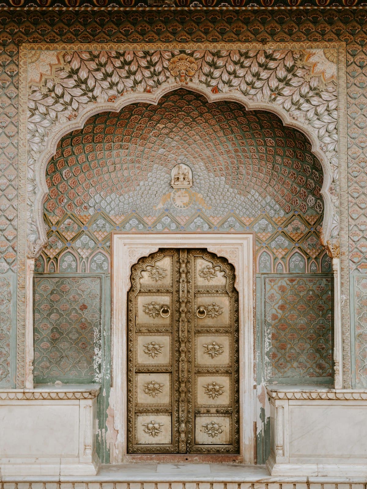 An ornate brass door set into a carved archway